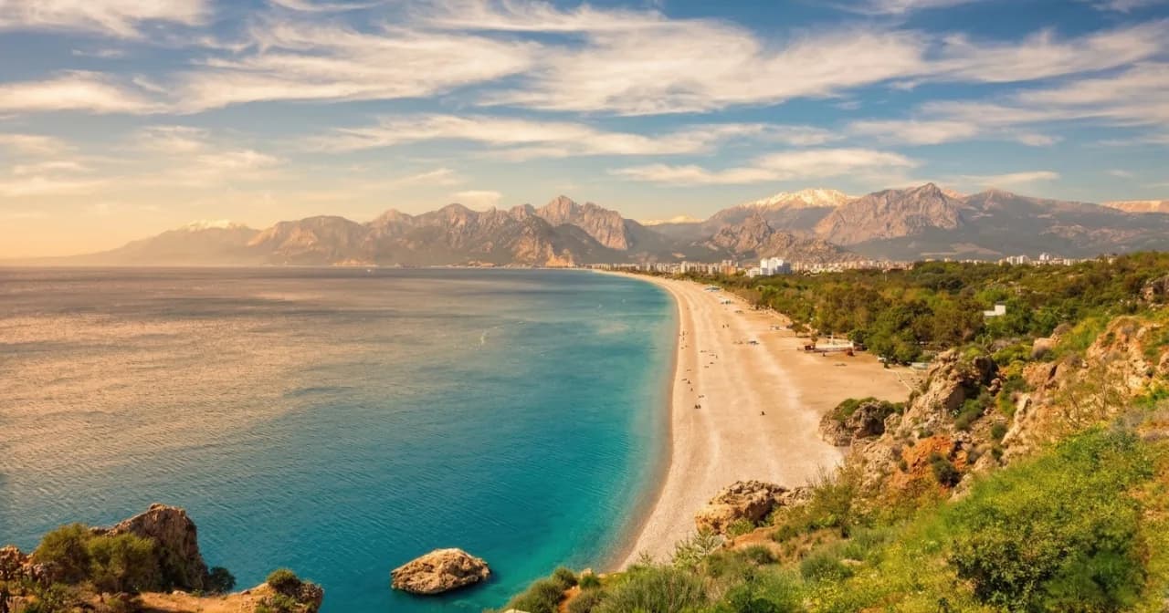 Konyaaltı beach in daylight, turquoise sea and the Taurus mountains across the bay